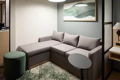 a living room with a couch and a table at Hyatt Place Montreal Airport in Dorval
