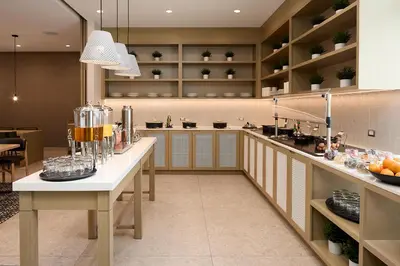 a large kitchen with a counter with drinks on it at Hyatt Place Montreal Airport in Dorval