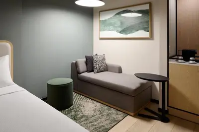 a room with a couch and a table and a bed at Hyatt Place Montreal Airport in Dorval