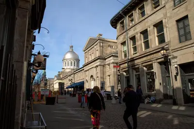 a group of people walking down a street with buildings at Spacious two stories condo in old port free parking in Montréal