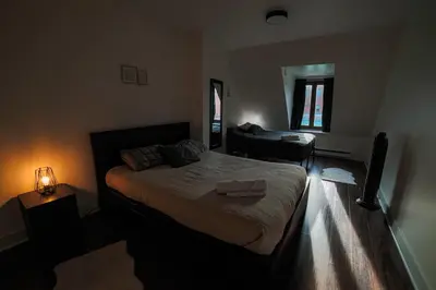 a bedroom with a bed and a living room at Spacious two stories condo in old port free parking in Montréal