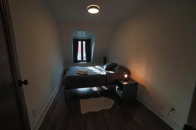 a small bedroom with a bed and a window at Spacious two stories condo in old port free parking in Montréal