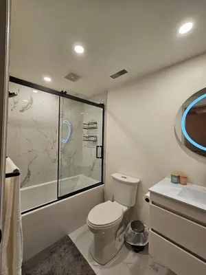 a bathroom with a shower and a toilet and a sink at Spacious two stories condo in old port free parking in Montréal