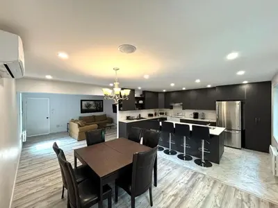 a dining room and kitchen with a table and chairs at Bedford 2 in Montréal