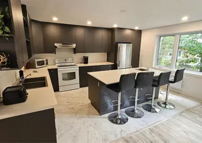 a kitchen with a island with bar stools in it at Bedford 2 in Montréal