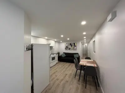 a kitchen and living room with a table and a refrigerator at Bedford 2 in Montréal
