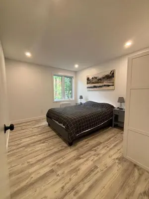 a bedroom with a bed and a wooden floor at Bedford 2 in Montréal