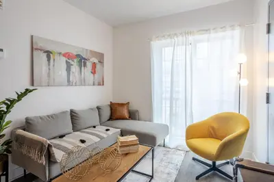 a living room with a couch and a yellow chair at Stylish 3BR in Griffintown in Montréal