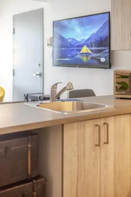 a kitchen with a sink and a tv on the wall at Stylish 3BR in Griffintown in Montréal