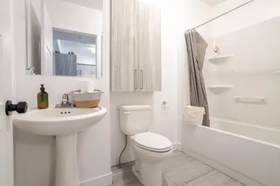 a white bathroom with a toilet and a sink at Stylish 3BR in Griffintown in Montréal