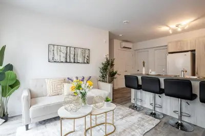 a living room with a couch and a kitchen at Fashionable 3BR in Griffintown in Montréal