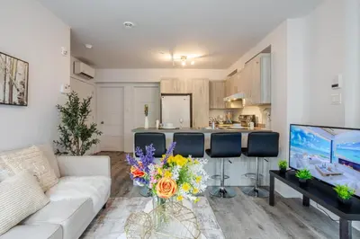 a living room with a couch and a kitchen at Fashionable 3BR in Griffintown in Montréal