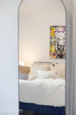 a bedroom with a bed and a mirror at Fashionable 3BR in Griffintown in Montréal