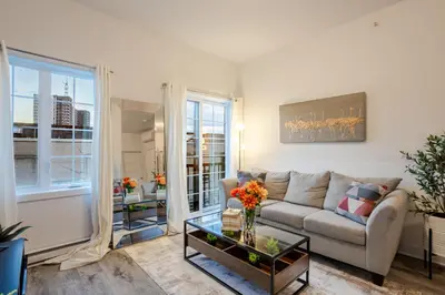 a living room with a couch and a table at Chic and Spacious 3 Bedrooms in Griffintown in Montréal