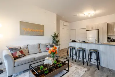 a living room with a couch and a kitchen at Chic and Spacious 3 Bedrooms in Griffintown in Montréal