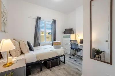 a bedroom with a bed and a desk and a window at Chic and Spacious 3 Bedrooms in Griffintown in Montréal
