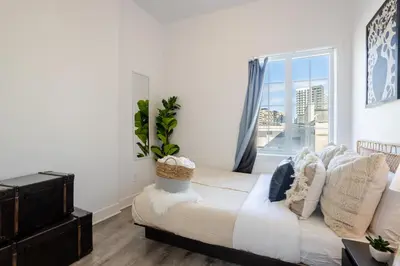 a bedroom with a bed and a large window at Bright and Beautiful 3 Bedroom in Griffintown in Montréal