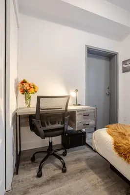 a bedroom with a desk and a chair next to a bed at Bright and Beautiful 3 Bedroom in Griffintown in Montréal