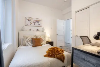 a white bedroom with a bed with a furry blanket on it at Bright and Beautiful 3 Bedroom in Griffintown in Montréal