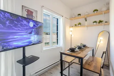 a room with a table and a large screen on the wall at Bright and Beautiful 3 Bedroom in Griffintown in Montréal