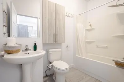 a white bathroom with a toilet and a sink at Bright and Beautiful 3 Bedroom in Griffintown in Montréal