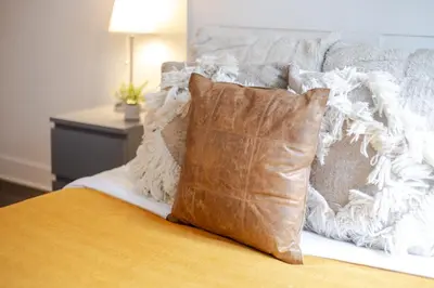 a bed with a brown pillow and a white blanket at Cozy and Spacious Condo Downtown in Montréal