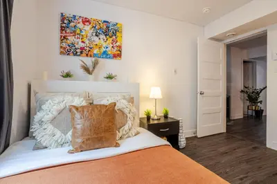 a bedroom with a bed and a painting on the wall at Cozy and Spacious Condo Downtown in Montréal