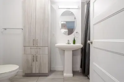 a white bathroom with a sink and a mirror at Cozy and Spacious Condo Downtown in Montréal