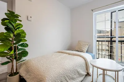 a bedroom with a bed and a plant and a window at Modern 3BR in Griffintown in Montréal