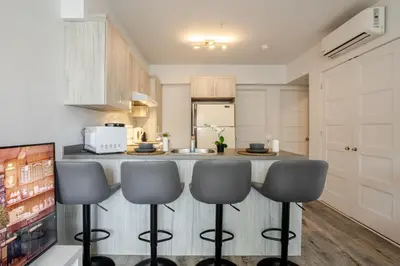 a kitchen with a counter with four bar stools at Modern 3BR in Griffintown in Montréal