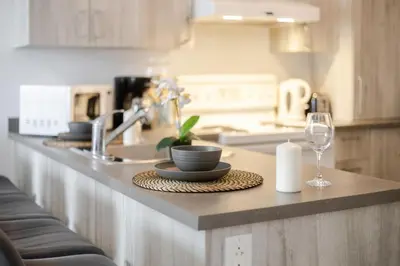 a kitchen counter with a sink and a glass of wine at Modern 3BR in Griffintown in Montréal