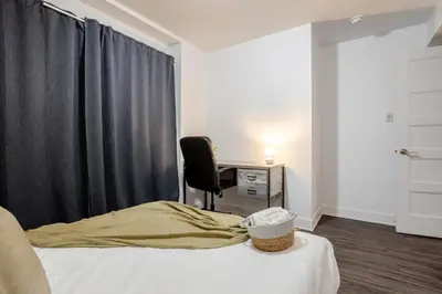 a bedroom with a bed and a desk and a chair at Amazing 4 Bedroom Unit in Downtown in Montréal