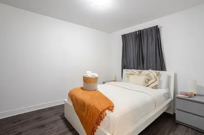 a white bedroom with a bed and a window at Amazing 4 Bedroom Unit in Downtown in Montréal