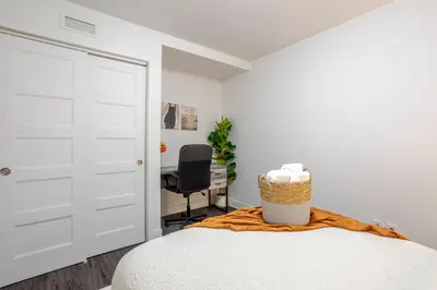 a bedroom with a white door and a chair at Amazing 4 Bedroom Unit in Downtown in Montréal