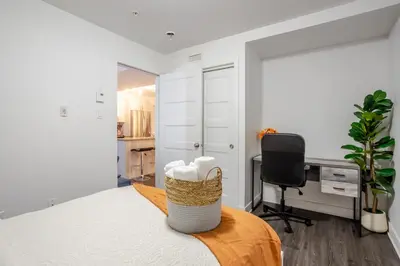 a bedroom with a bed with a desk and a chair at Amazing 4 Bedroom Unit in Downtown in Montréal