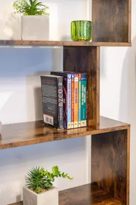 a group of books on a wooden shelf at Amazing 4 Bedroom Unit in Downtown in Montréal