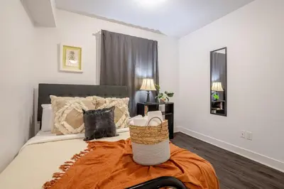 a bedroom with a bed with an orange blanket at Amazing 4 Bedroom Unit in Downtown in Montréal