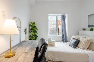 a room with a table and a bed and a window at Modern Apartment in the Heart of Griffintown in Montréal