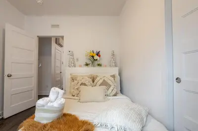 a bedroom with a white bed with a furry rug at Modern Apartment in the Heart of Griffintown in Montréal