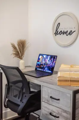 a laptop computer sitting on a desk with a chair at Modern Apartment in the Heart of Griffintown in Montréal
