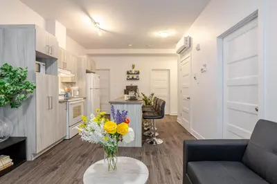 a living room with a couch and a table with a vase of flowers at Modern Apartment in the Heart of Griffintown in Montréal