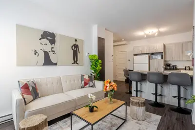 a living room with a couch and a kitchen at Wonderful 4 BR Home in the heart of Downtown in Montréal