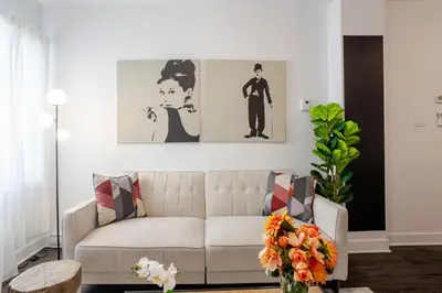 a living room with a white couch and two paintings at Wonderful 4 BR Home in the heart of Downtown in Montréal