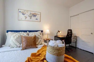 a bedroom with a bed with a desk and a chair at Wonderful 4 BR Home in the heart of Downtown in Montréal