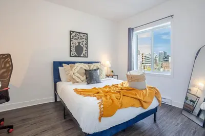 a bedroom with a bed and a large window at Luxurious 4 BR Suite in Griffintown in Montréal