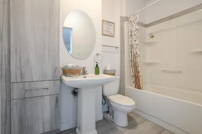 a bathroom with a sink and a toilet and a mirror at Luxurious 4 BR Suite in Griffintown in Montréal