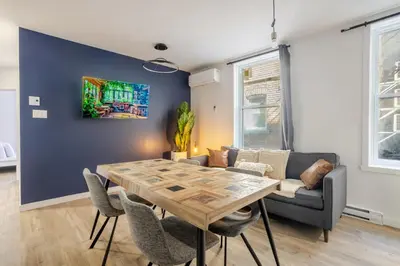 a dining room with a table and a couch at Warm 2BR in the Heart of Plateau MTL in Montréal