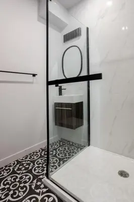 a shower with a glass door in a bathroom at Warm 2BR in the Heart of Plateau MTL in Montréal