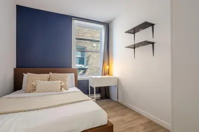 a bedroom with a bed and a blue wall at Warm 2BR in the Heart of Plateau MTL in Montréal