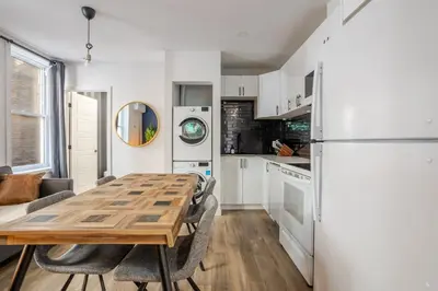a kitchen with a table and a refrigerator at Warm 2BR in the Heart of Plateau MTL in Montréal